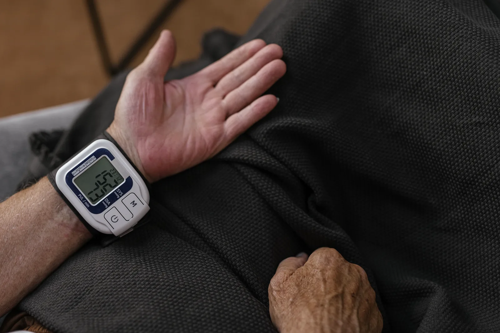 가정에서 혈압을 측정하는 어르신. An older adult checking blood pressure at home.