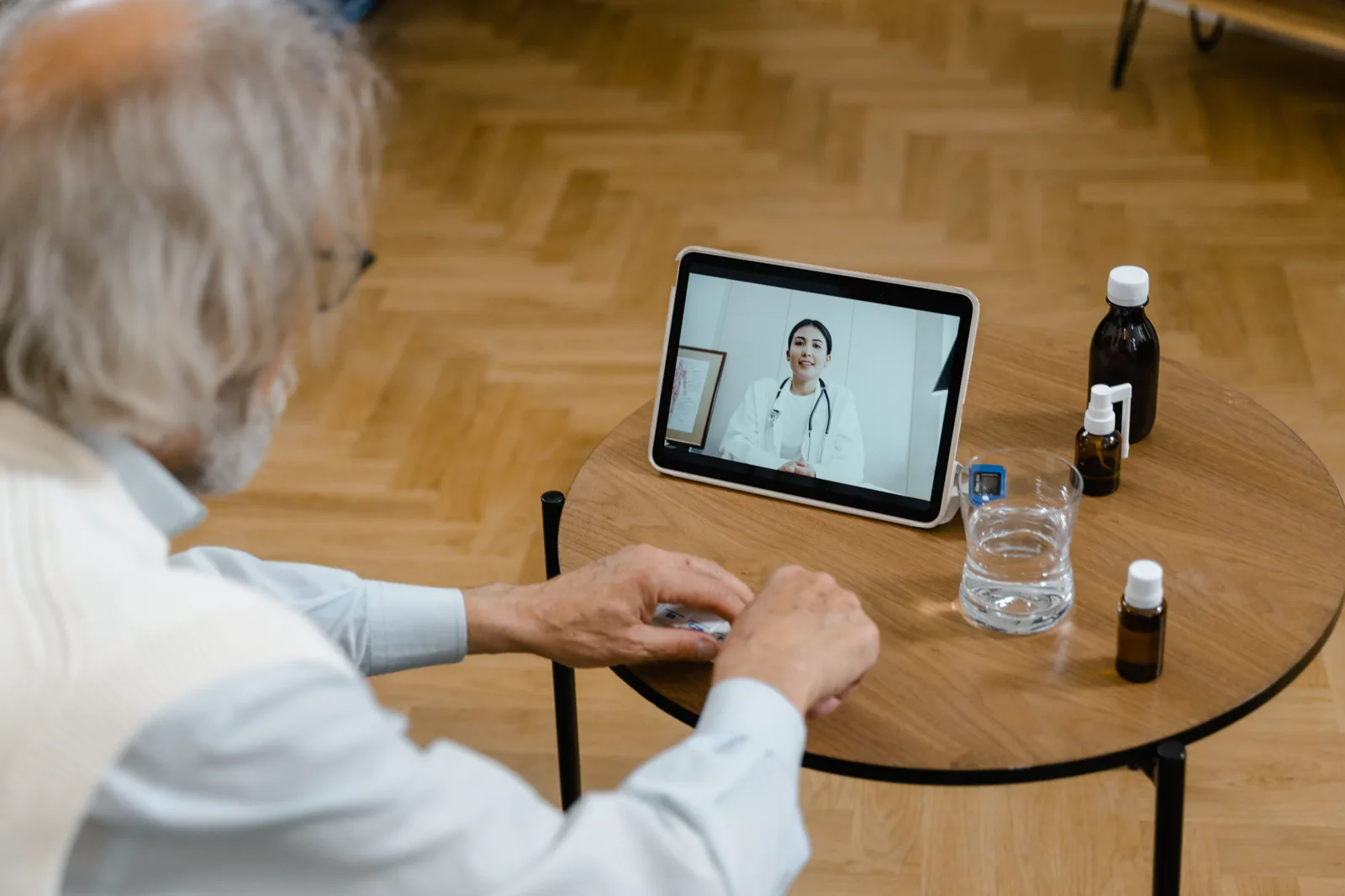 태블릿으로 의료진과 상담하는 어르신. An older adult speaking with a care provider by tablet.